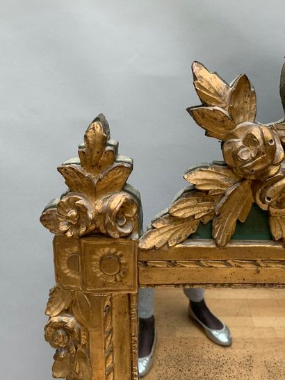 null MIROIR en bois sculpté et doré à décor de frises de perles et chutes de feuillages,...