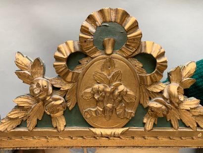 null Carved and gilded wood mirror decorated with pearl friezes and foliage, topped...