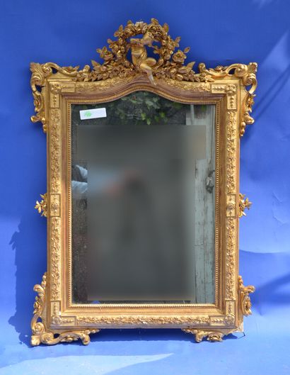 null A wood and gilded stucco mirror with a rich decoration of foliage with fruits,...