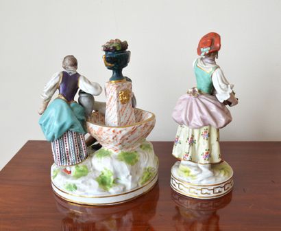 null Two polychrome porcelain groups: The flower seller and Scene with a fountain...