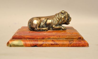  School of the XIXth century 
Reclining Lion 
Silvered and gilded bronze on a red...