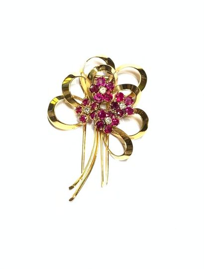 EPINGLE DE REVERS en or (750) à décor de fleurs, sertie de petits rubis et diamants....