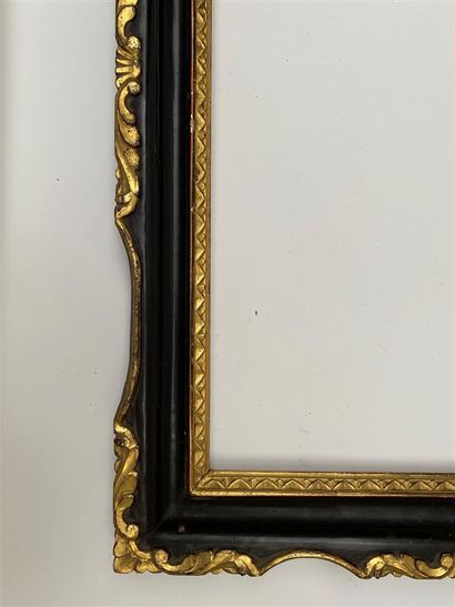 null A blackened and gilded moulded wooden frame decorated with rais-de-coeur, violin...