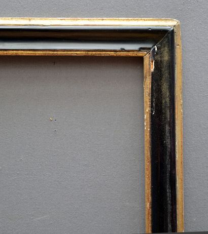 null A moulded and blackened fir frame with a gilded border and foliage.

Italy,...