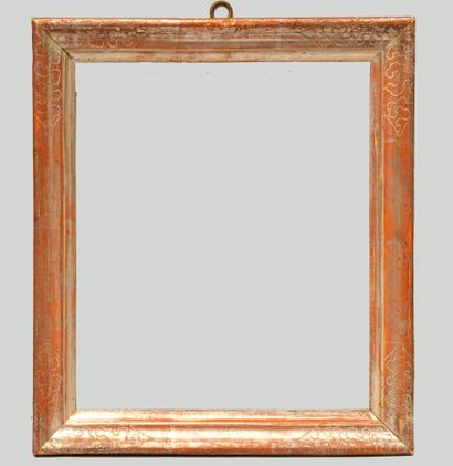 null A moulded and silvered wooden frame with a reparure decoration in the corners.

Italy,...