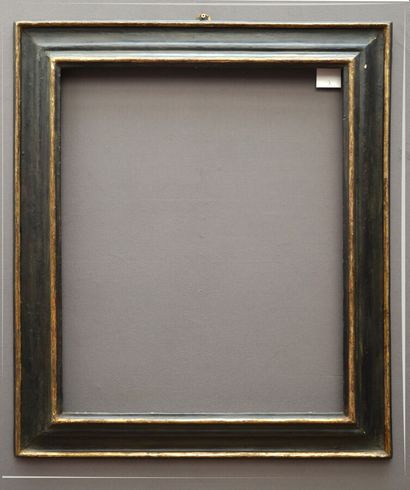 A blackened molded wood frame with an old...