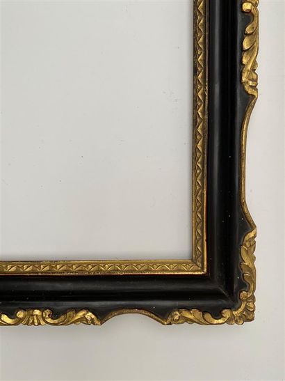 null A blackened and gilded moulded wooden frame decorated with rais-de-coeur, violin...
