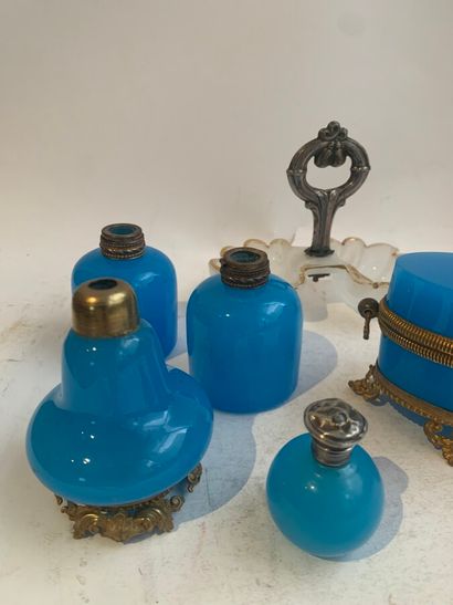  Lot en verre opalin bleu comprenant quatre flacons et un coffret ovale à monture...