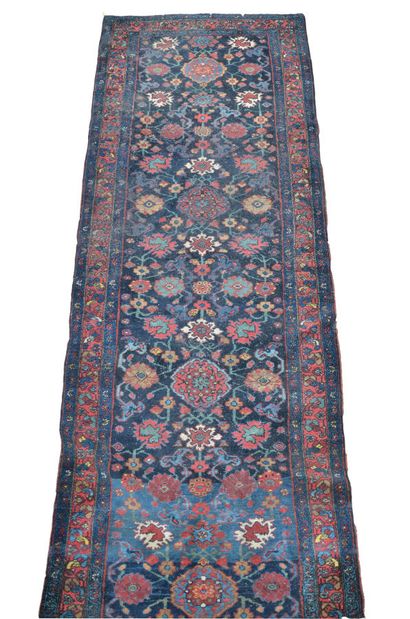 null Persian carpet in polychrome wool with geometric decoration on a blue background....