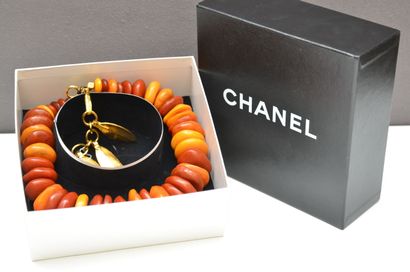 null CHANEL - Necklace in amber-colored resin, gilded bronze clasp holding charms...