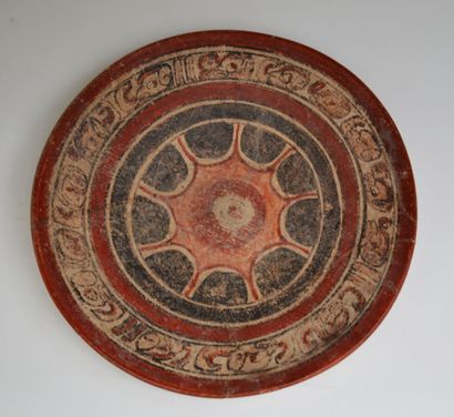 null Ceremonial dish with a red solar motif on a black background surrounded by a...