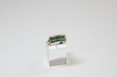 null RING 
18k white gold ring set with a line of calibrated emeralds in a border...