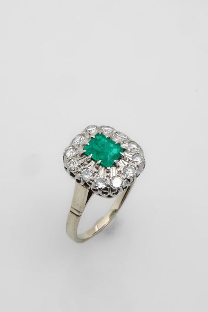 null RING 
in 18k white gold, holding an emerald in a circle of brilliant-cut diamonds.
Finger...