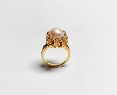 null BAGUE 
en or jaune 18k la monture ciselée retenant en son centre une perle dans...