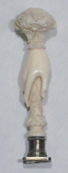 null Un CACHET en ivoire sculpté en forme de main féminine tenant un cachet et sommé...