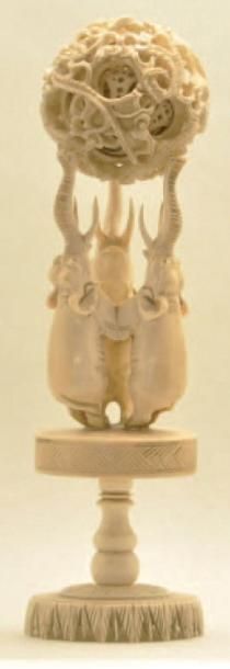 null BOULE DE CANTON en ivoire sculpté composée de trois éléphants à la trompe dressée....