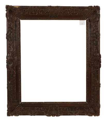 A molded and carved oak frame decorated with...