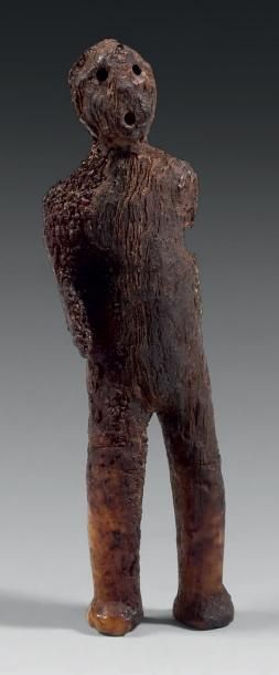 null AMULETTE représentant un personnage en ivoire fossilisé, patine brun foncé et...