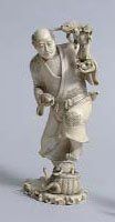 null OKIMONO en ivoire, Gamma Sennin debout tenant des crapauds et une petite statuette...