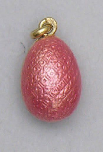 null PENDENTIF en alliage d'or en forme de petit oeuf émaillé rose sur fond de guillochage...