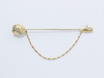 CARTIER Épingle de cravate en or 750 millièmes, décorée d'une sphère godronnée ponctuée...