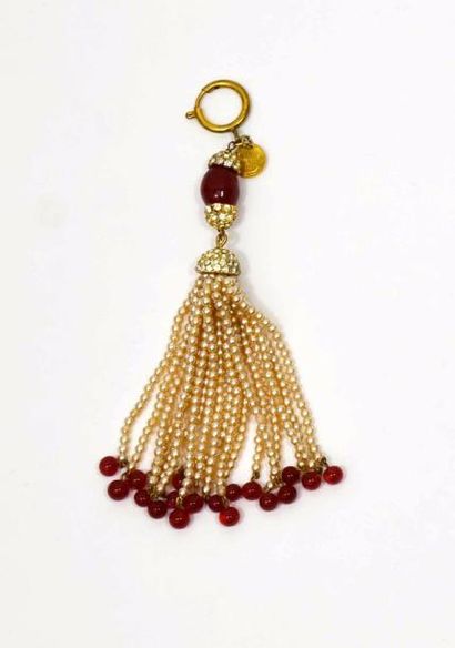 null CHANEL, pendentif pompon métal doré en perles, pierres rouges et strass. 

...