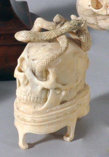 null OKIMONO en ivoire sculpté figurant un crâne sommé d'un serpent autour auquel...