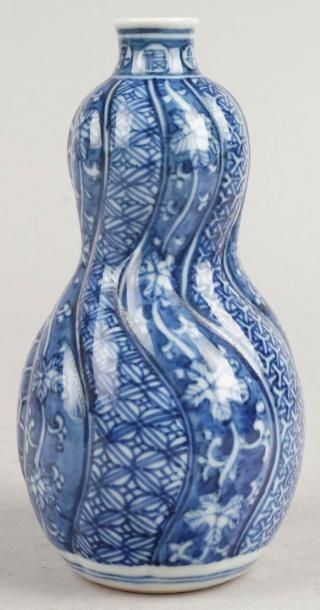JAPON, XIXe siècle, IMARI BOUTEILLE À SAKÉ à décor bleu blanc de motifs géométriques....