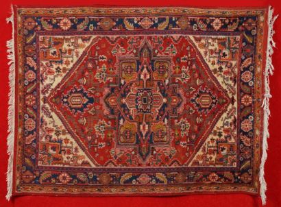 null Tapis INDO HERIZ vers 1970 à décor floral géométrique sur fond rouge brique....