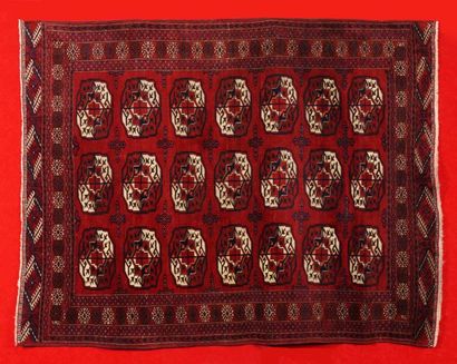 null TAPIS TEKKE BOUKARA (Turkmène), Milieu XIX siècle. Fond lie de vin à décor de...