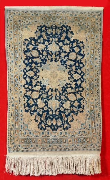 null FIN TAPIS NAÏM (Iran) en laine et soie à fond bleu nuit à décor floral. 103...
