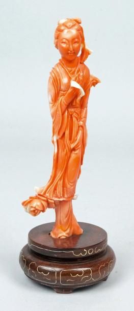 CHINE Statuette en corail sculpté figurant une femme tenant des fleurs. H.: 13,5...