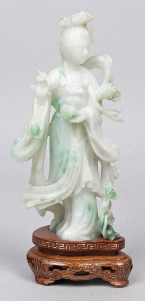 CHINE STATUETTE en jadéite sculptée figurant une femme tenant des fleurs. H.: 16...