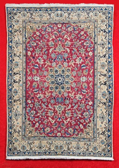 null Tapis NAÏM (Iran) vers 1980 sur fond rubis à décor floral en laine et soie.
170...