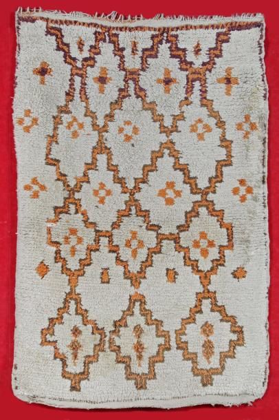 null TAPIS BERBERE vers 1960. (petits trous). Fond ivoire à semis de croisillons....