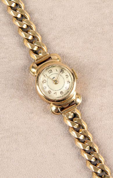 null BRACELET-MONTRE DE DAME en or jaune des années 1940, cadran rond émaillé à chiffres...