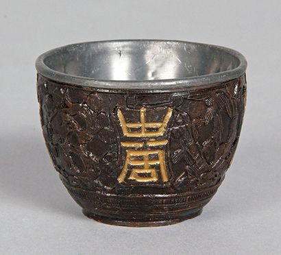 CHINE, XIXe siècle COUPE en noix de coco à décor sculpté et doré de caractères Fu...