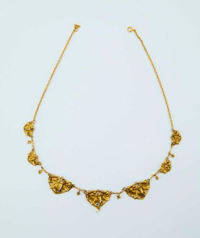  Un collier draperie en or 750/1000e à décor de pampres de vigne, orné de petites...
