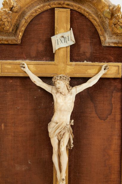 null * Christ en croix en ivoire dans cadre en bois et stuc doré sur fond tendu de...