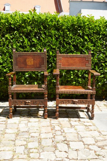 null Suite de deux fauteuils en bois et cuir à décor de semences l'un à dossier armorié.

Style...