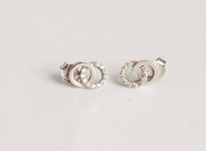 null Two pairs of silver and rhinestone earrings. One featuring two interlocking...