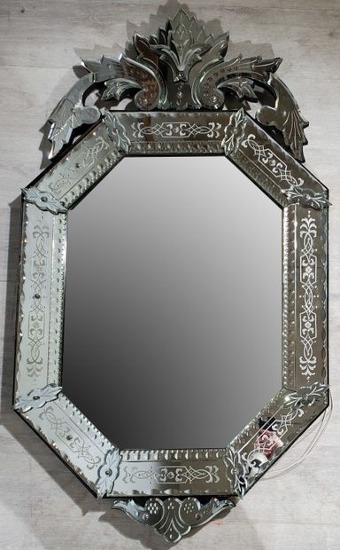 null Venetian mirror with stylized scrolls and beveled glass. Glass frame with engraved...
