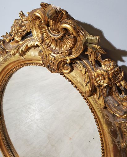 null Oval-shaped MIRROR, wood and stucco with gilded patina, string of pearls and...