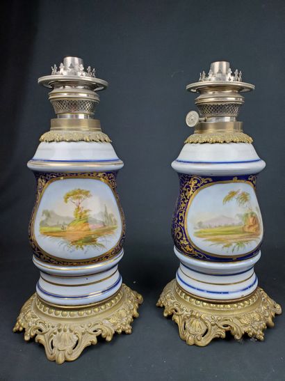 null Pair of polychrome and gilt porcelain oil lamps, gilt bronze structure, depicting...