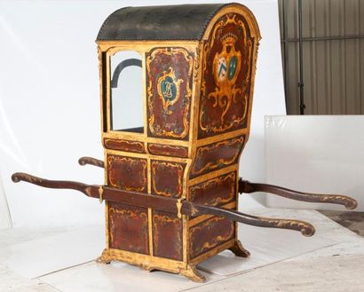 null Une chaise à porteurs Louis XV en bois doré à décor rocaille, reposant sur des...