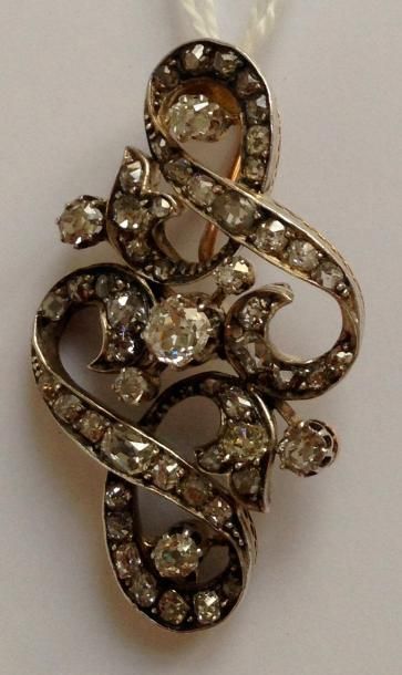 null Pendentif en argent et or jaune formant des volutes et serti de diamants taillés...