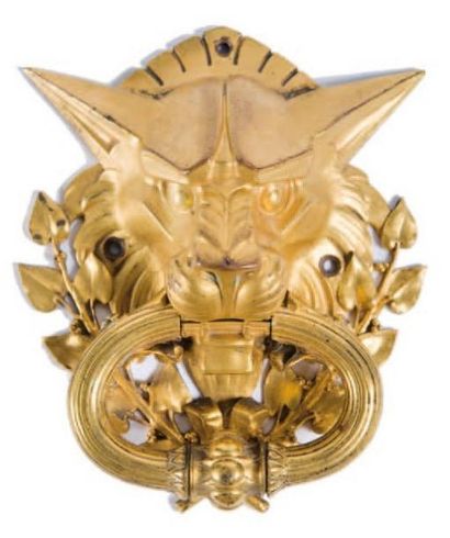 ANONYME Heurtoir en bronze doré à décor de tête de lion stylisée et feuillages. Début...