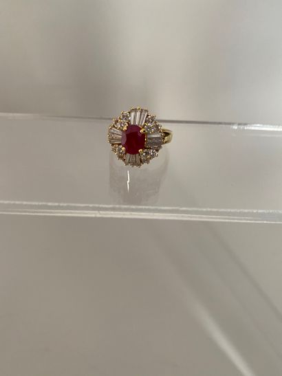null 750 thousandths gold ring decorated with an oval ruby in a circle of round diamonds...