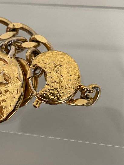 null YVES SAINT LAURENT Bracelet gourmette à breloques médaille en métal doré - Signé.

Longueur...