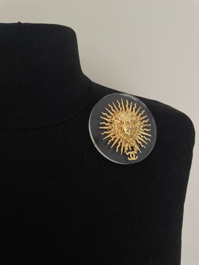 null CHANEL Brooch sun clip in gilded metal on a circular plexiglass background with...